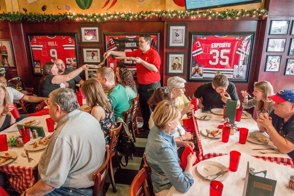 A team being served pizza at a Chicago restaurant