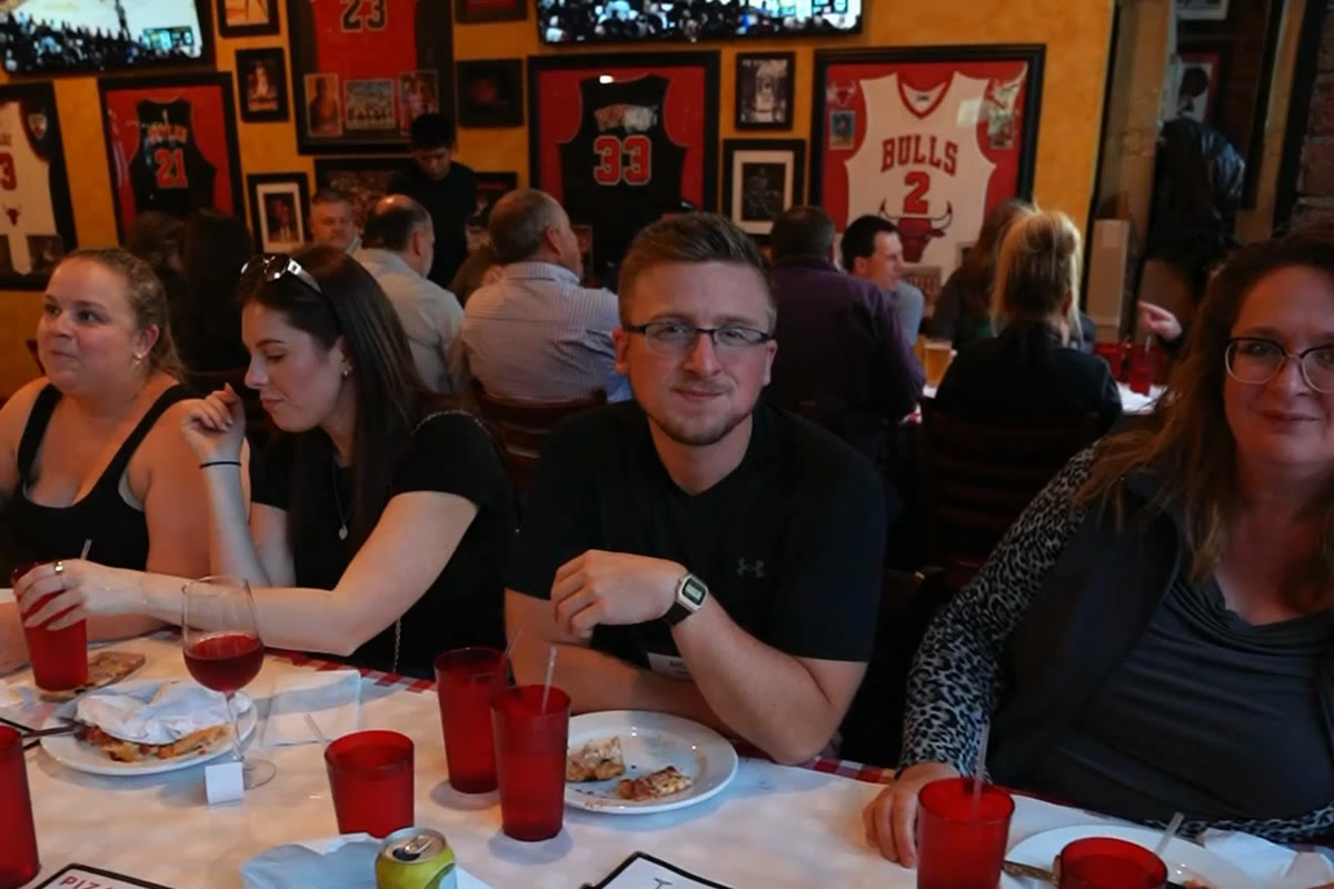 A company team at the table mid-meal at a Chicago pizzeria during an onsite afternoon